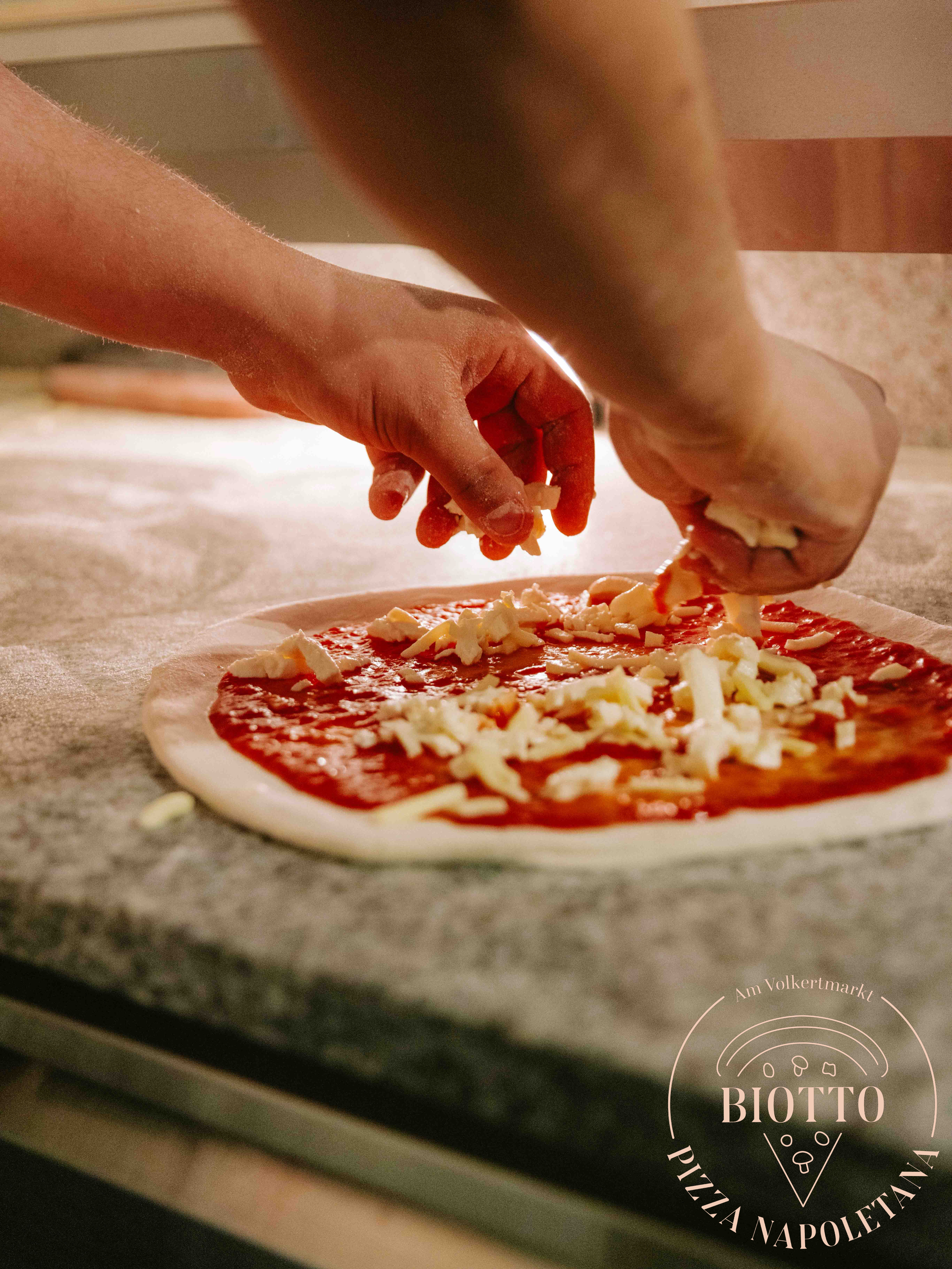 Pizza wird frisch in der Küche belegt
