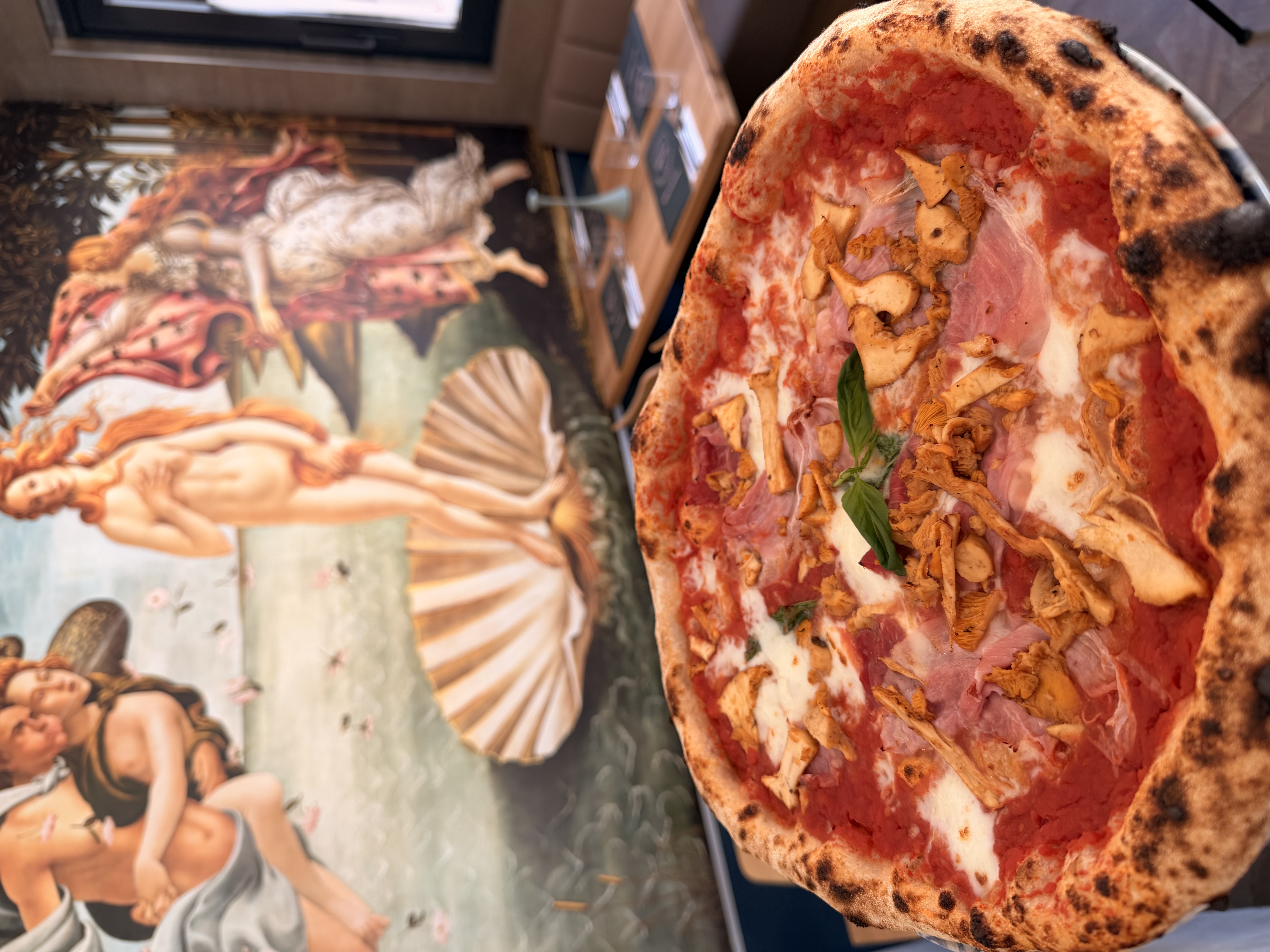 Detailaufnahme einer Pizza mit Pfifferlingen und Basilikum
