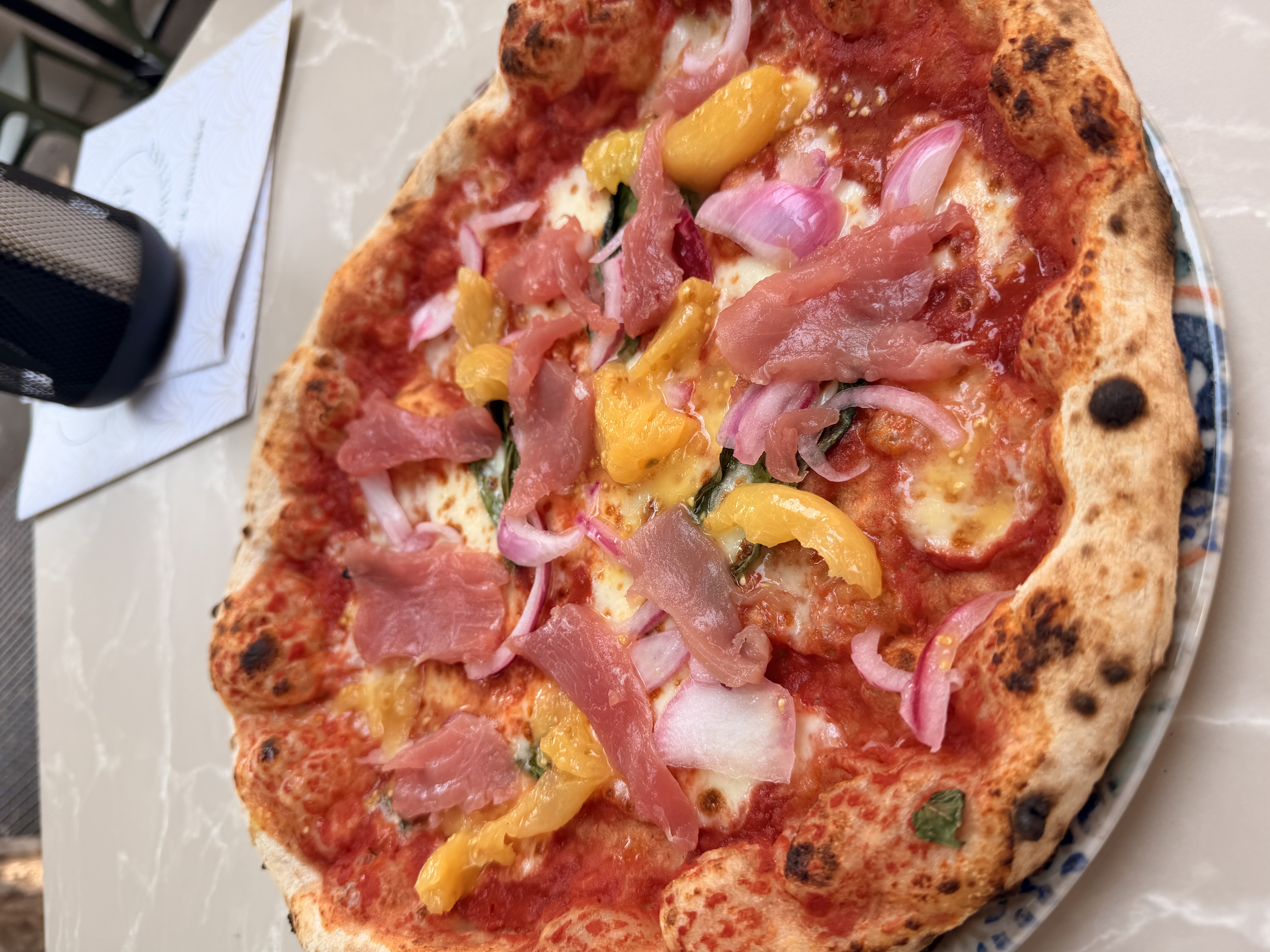 Pizza mit Thunfisch, gelben Tomaten und roten Zwiebeln