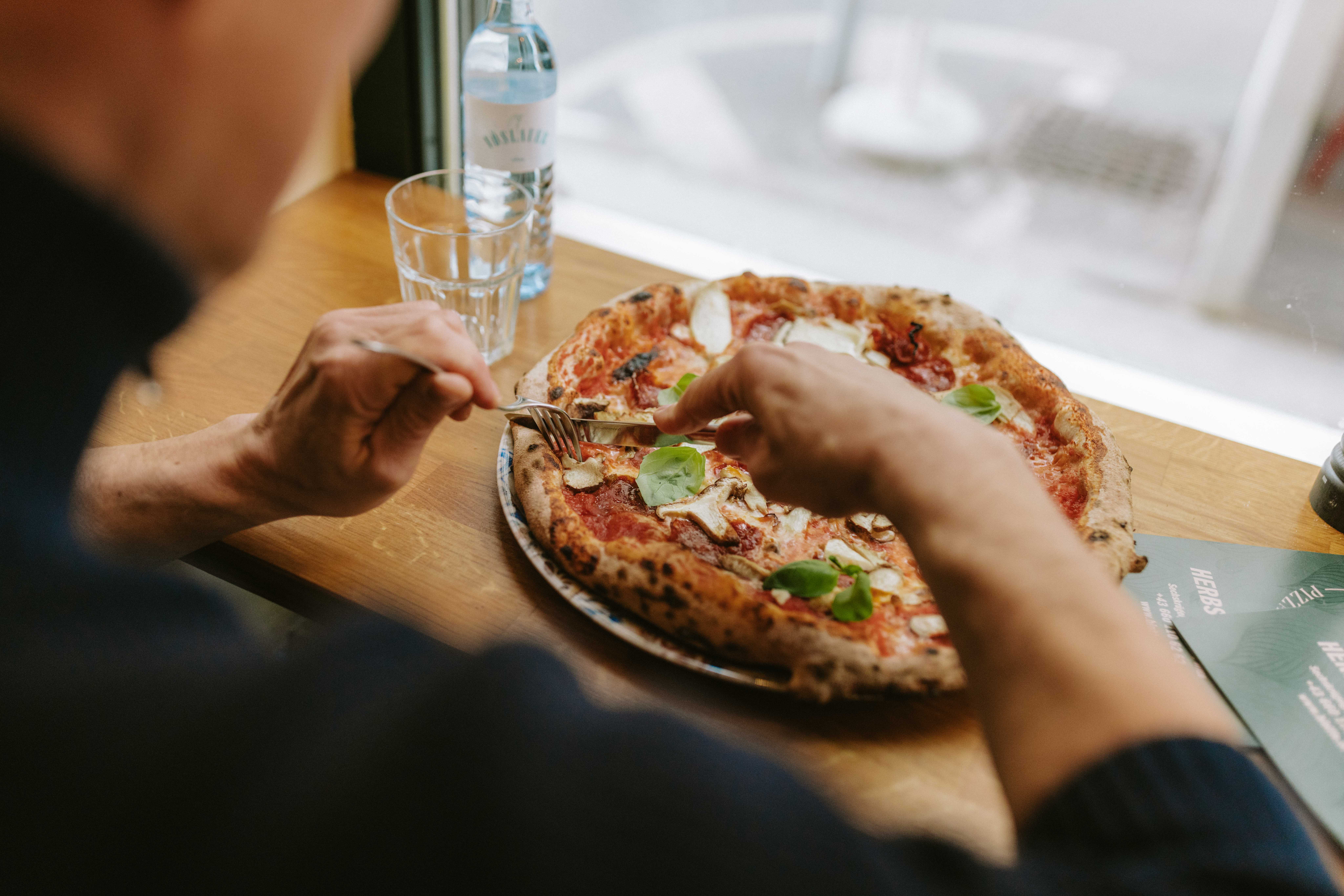 Gast genießt eine Pizza im Lokal